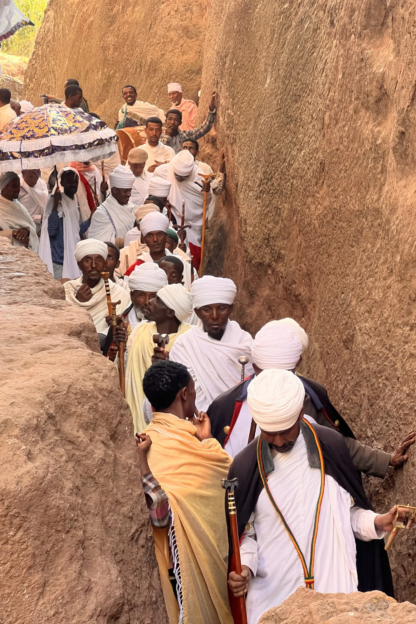 Fedeli e sacerdoti ortodossi con abiti bianchi tradizionali celebrano la festa del Timkat tra le trincee di roccia a Lalibela, in Etiopia.