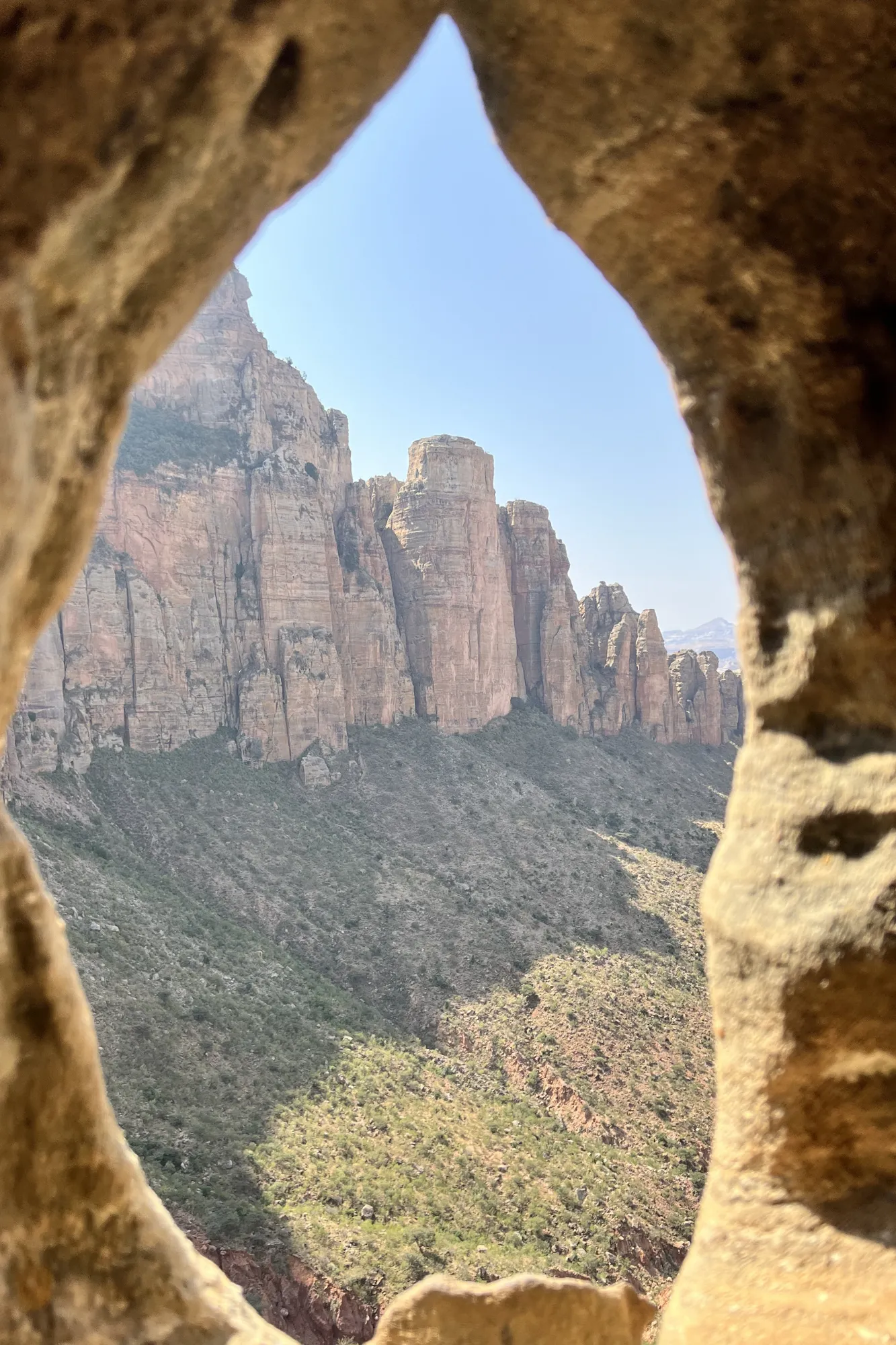 Panorama delle montagne del Gheralta incorniciato da una finestra di roccia naturale presso la chiesa rupestre di Abuna Yemata, in Etiopia.