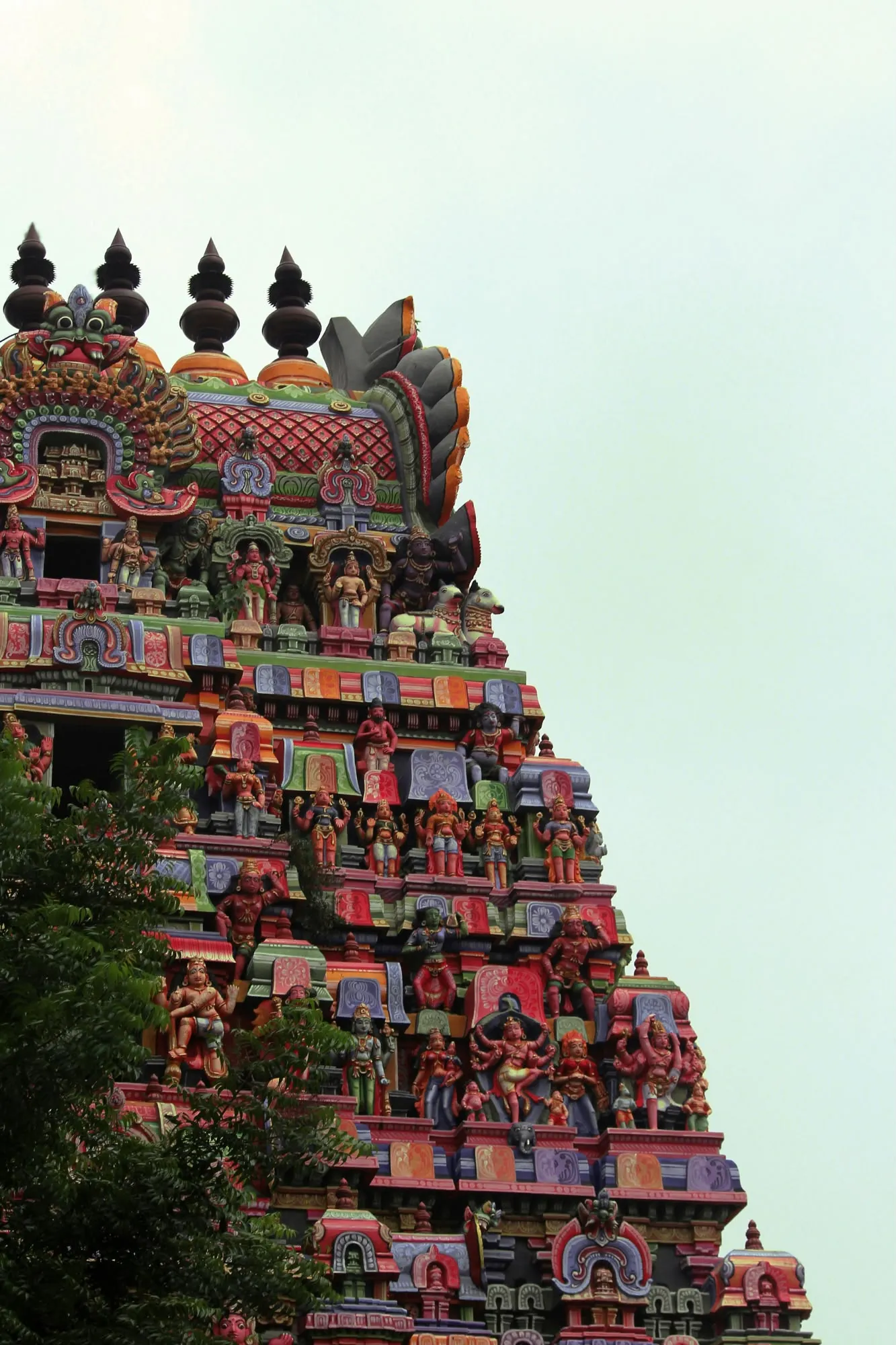 Dettaglio architettonico di una torre Gopuram di un tempio induista ricca di sculture colorate e divinità.