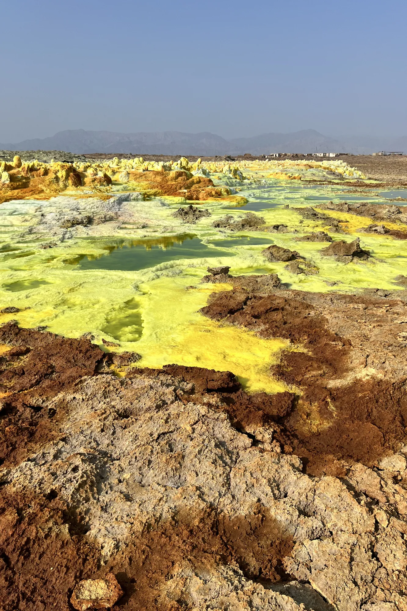Paesaggio alieno con sorgenti idrotermali gialle e depositi di sale del vulcano Dallol in Etiopia.