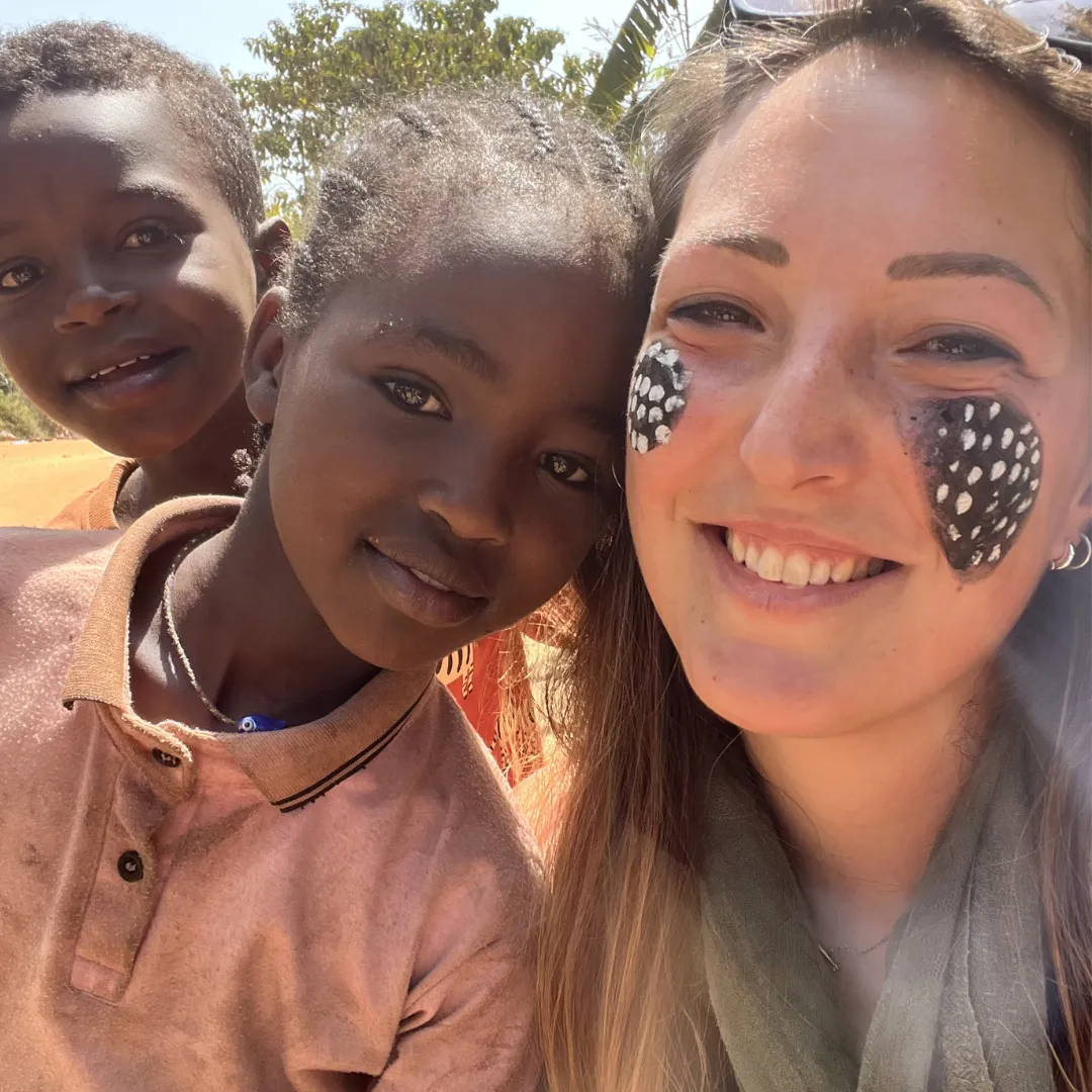 viaggiatrice Yagiu i n un selfie con una bambina e bambino della comunità mursi