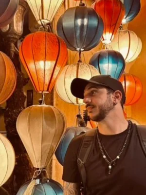 Ragazzo con cappello ammira le tradizionali lanterne colorate accese a Hoi An